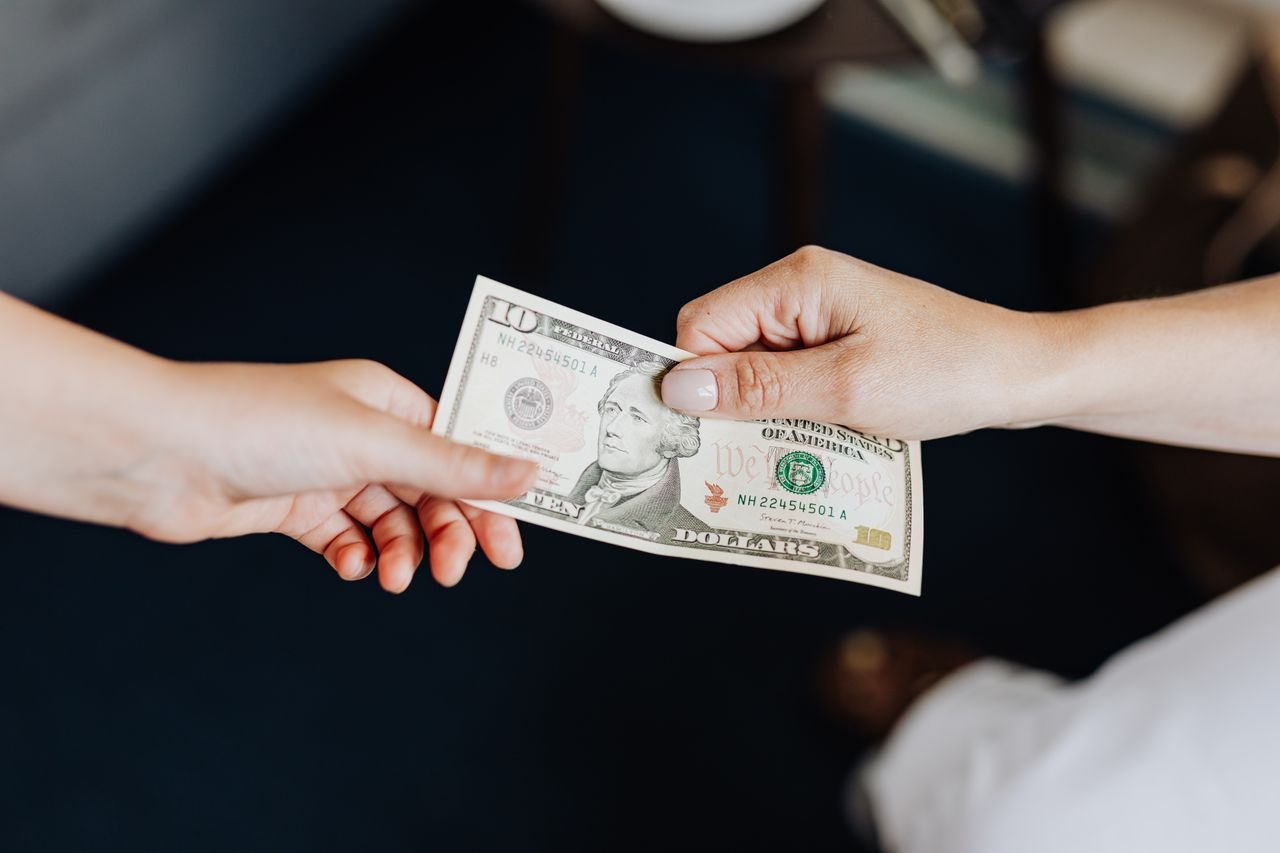 Crafting Captivating Headlines: Your awesome post title goes here Two people exchanging a ten dollar bill in a close-up hand-to-hand transaction.